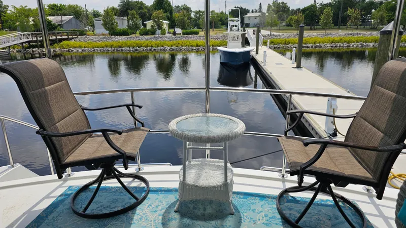 Slide: The Image of Deck view from 2005 Jefferson Marquessa 60 MY yacht, featuring chairs and a table by the water. - 24