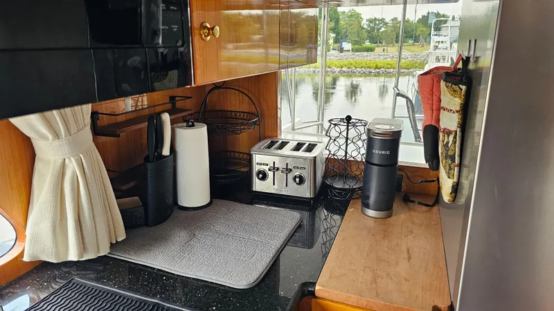 Slide: The Image of Compact kitchen in a 2005 Jefferson Marquessa 60 MY yacht with appliances and window view. - 31