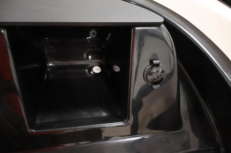 Slide: The Image of 2026 Bayliner V20 boat dashboard with storage compartment and power outlet. - 17