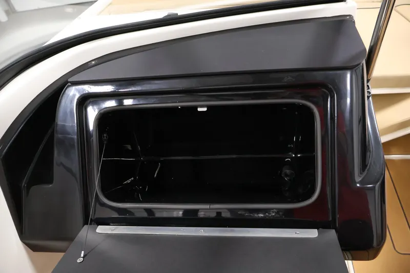 Slide: The Image of 2026 Bayliner V20 boat storage compartment, open and empty, with sleek black finish. - 23