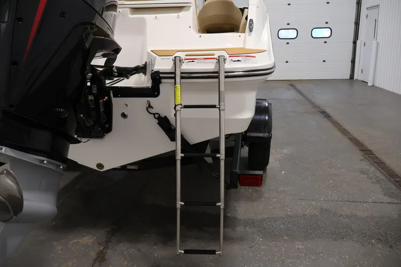 Slide: The Image of 2026 Bayliner V20 boat with ladder and outboard motor in a garage setting. - 32