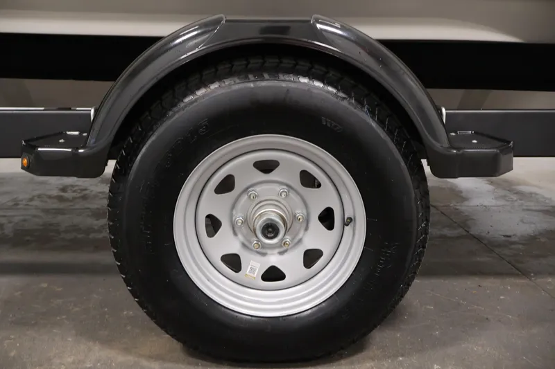 Slide: The Image of Trailer wheel of a 2026 Bayliner V20 boat, featuring a sturdy tire and metal rim. - 38