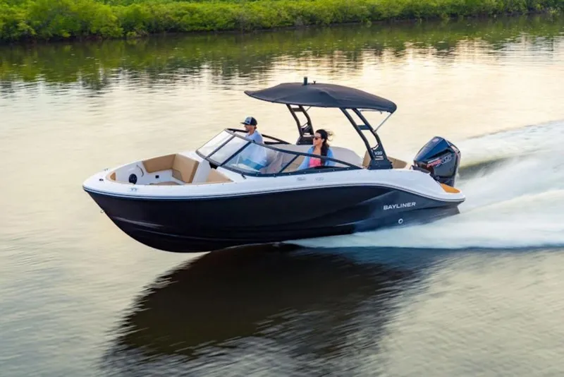 Slide: The Image of 2026 Bayliner V20 boat cruising on a calm river with lush greenery. - 42