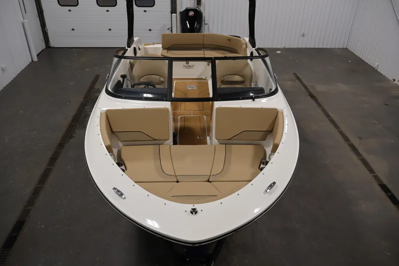 Slide: The Image of 2026 Bayliner V20 boat with beige seating, showcased in a garage setting. - 8