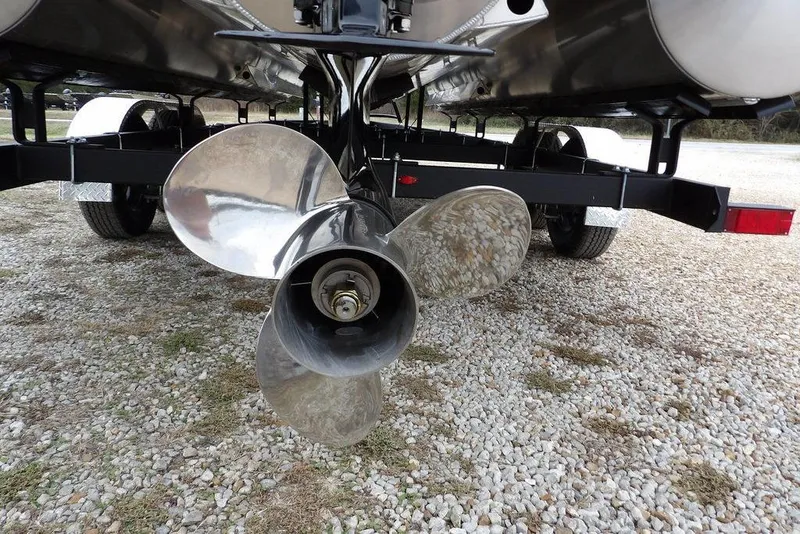 Slide: The Image of 2026 Bennington M Swingback 22 MSB boat propeller on a trailer, parked on gravel. - 45