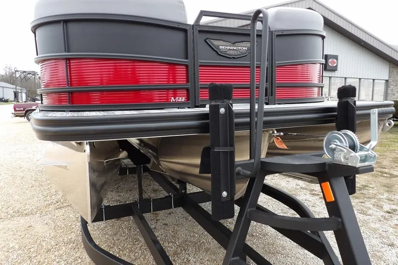 Slide: The Image of 2026 Bennington M Swingback 22 MSB pontoon boat on trailer, featuring sleek red and black design. - 50