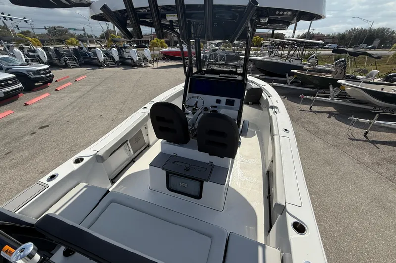 Slide: The Image of 2025 Sea Pro 245FLX Sandbar boat interior with dual seats and console, displayed outdoors. - 12