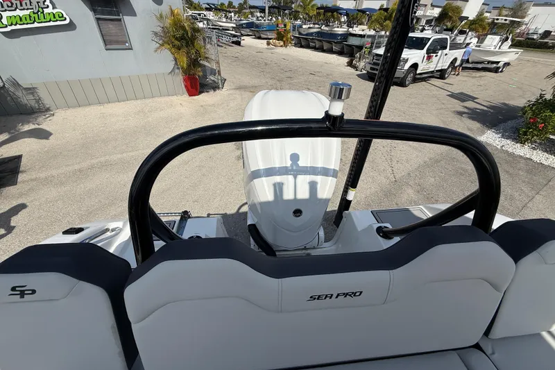 Slide: The Image of 2025 Sea Pro 245FLX Sandbar boat interior with outboard motor, docked at a marina. - 16