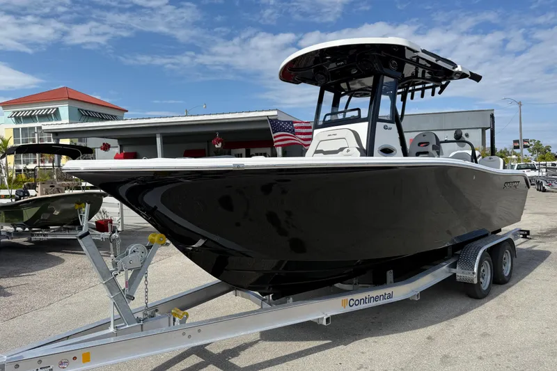 Slide: The Image of 2025 Sea Pro 245FLX Sandbar boat on trailer, displayed outdoors under blue sky. - 2