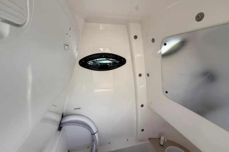 Slide: The Image of Interior of 2025 Sea Pro 245FLX Sandbar boat, featuring sleek white design and porthole window. - 35