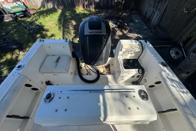 Slide: The Image of 1993 Hydra-Sports Bay Bolt 1900 boat with T-top, parked in a marina under clear skies. - 12