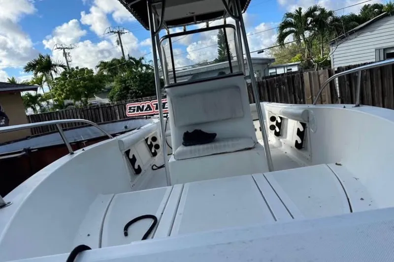 Slide: The Image of 1993 Hydra-Sports Bay Bolt 1900 boat with Mercury engine on trailer, under clear blue sky. - 2