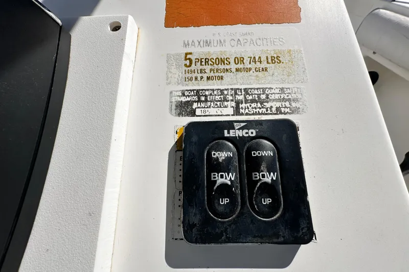 Slide: The Image of 1993 Hydra-Sports Bay Bolt 1900 boat capacity label and Lenco trim tab controls. - 23