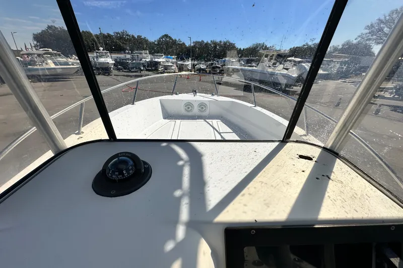 Slide: The Image of 1993 Hydra-Sports Bay Bolt 1900 boat interior with compass, docked among other boats. - 28