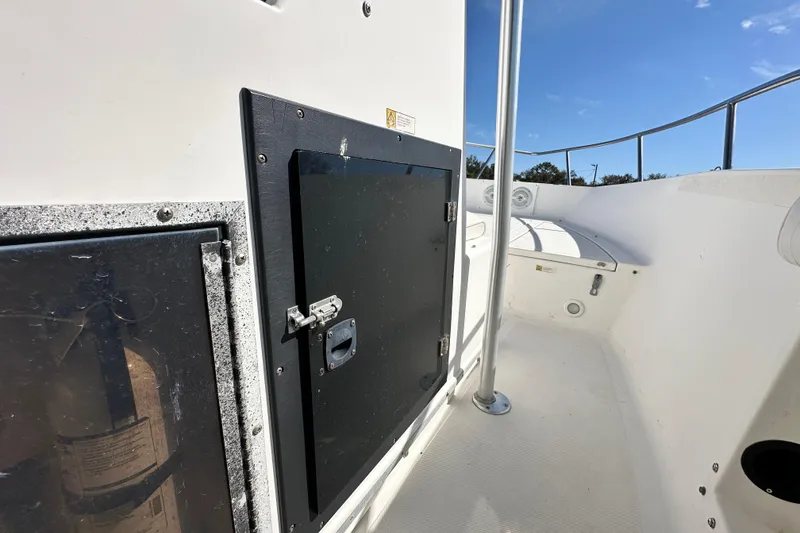 Slide: The Image of 1993 Hydra-Sports Bay Bolt 1900 boat interior with storage compartment and railing. - 34