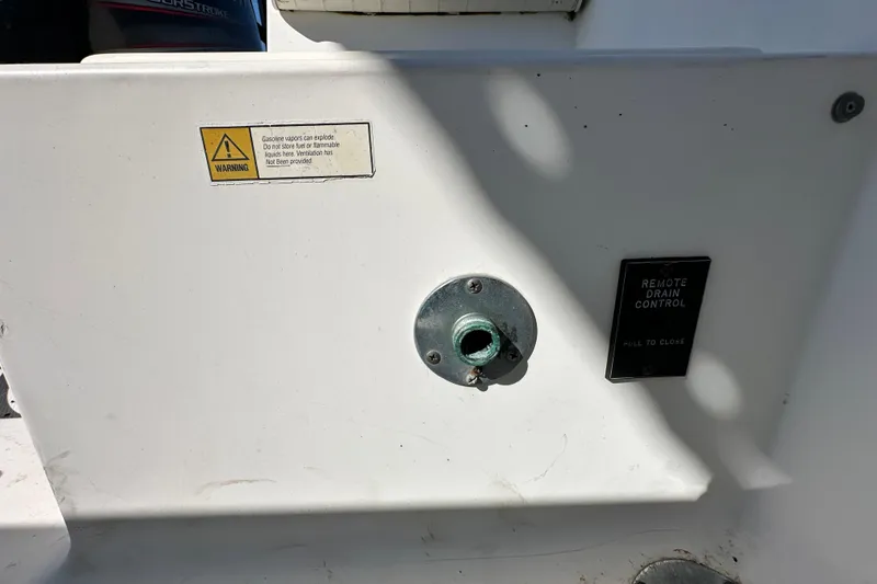 Slide: The Image of 1993 Hydra-Sports Bay Bolt 1900 boat detail with warning label and remote drain control. - 60