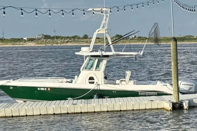 Slide: The Image of 2006 Everglades 260 Center Console boat docked by the water with fishing gear. - 2