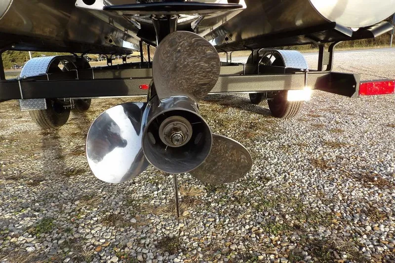 Slide: The Image of 2026 Bennington M Swingback 22 MSB boat propeller on a trailer, parked on gravel. - 39