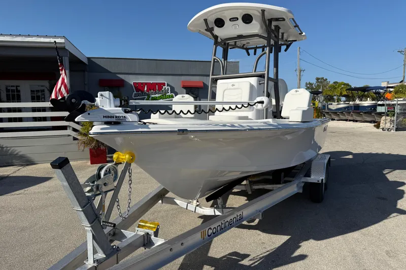 Slide: The Image of 2025 Sea Pro 210 Bay boat on trailer at dealership, sunny day, American flag visible. - 3