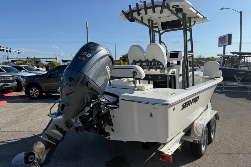 Slide: The Image of 2025 Sea Pro 210 Bay boat with Yamaha engine on trailer, American flag in background. - 8