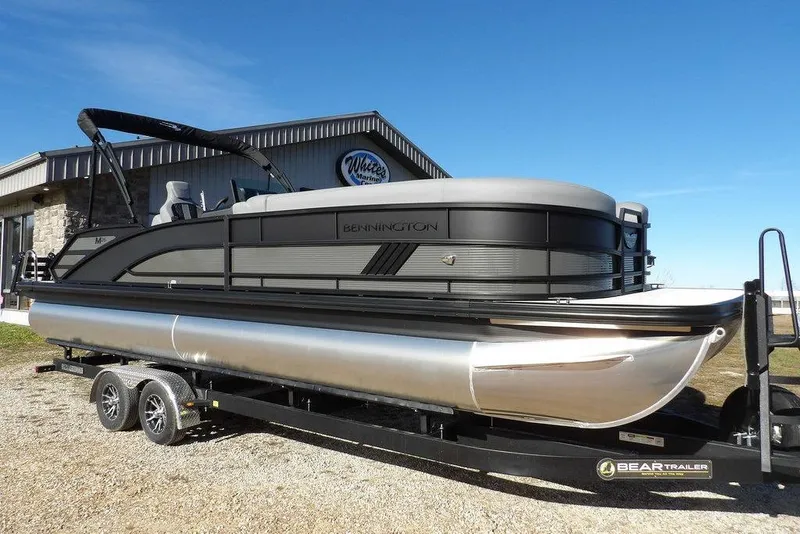 The Image of 2026 Bennington M Swingback 26 MSB pontoon boat on trailer, parked outdoors. - 1