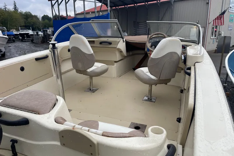 Slide: The Image of 2004 Triumph 191 Fish & Ski boat with dual console seating in a marina setting. - 5