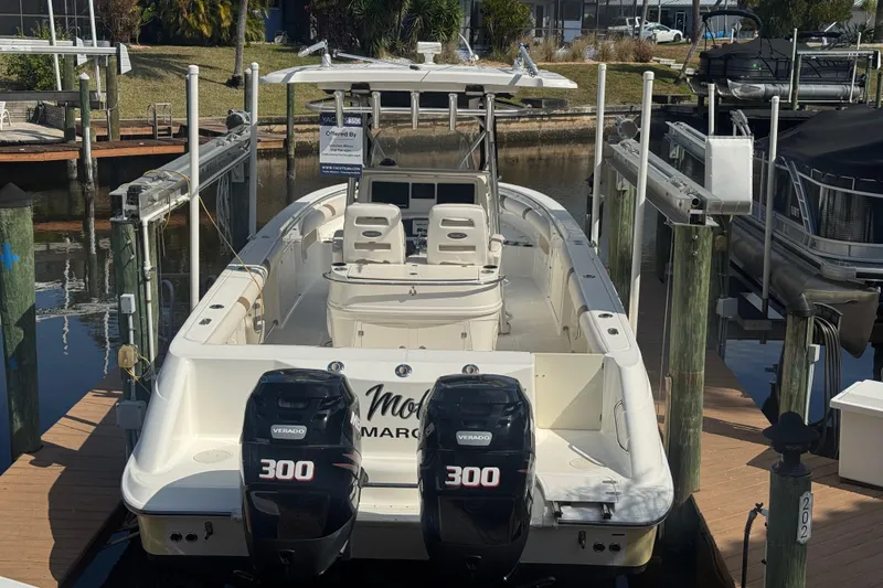 Slide: The Image of 2005 Boston Whaler 320 Outrage boat interior with seating and storage, docked by calm water. - 25