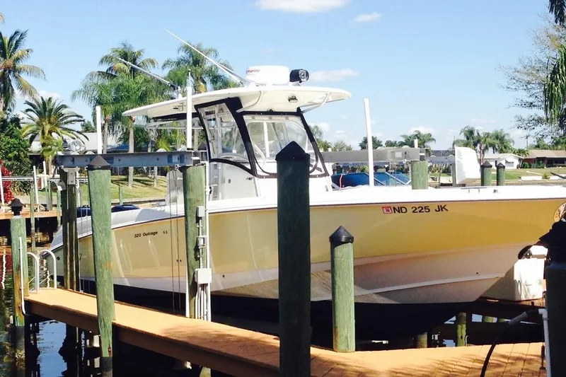 Slide: The Image of 2005 Boston Whaler 320 Outrage boat docked at twilight, fully covered and secured. - 3