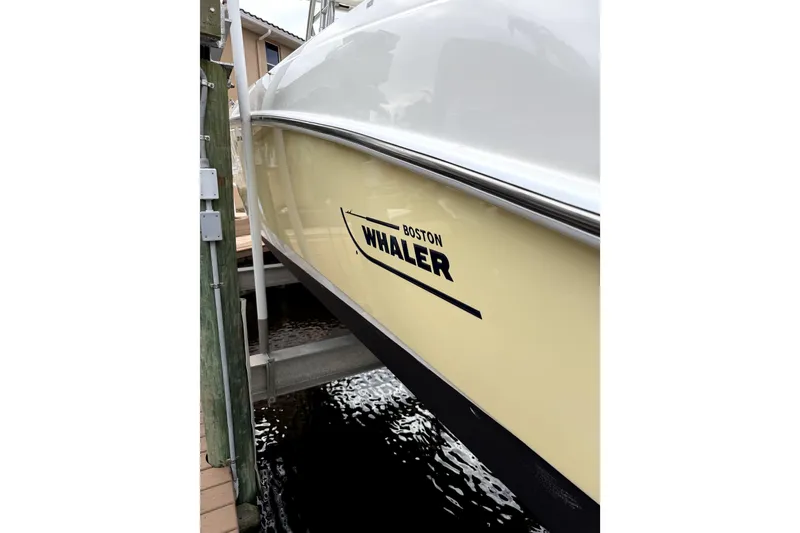 Slide: The Image of 2005 Boston Whaler 320 Outrage boat docked, showcasing its sleek design and branding. - 9