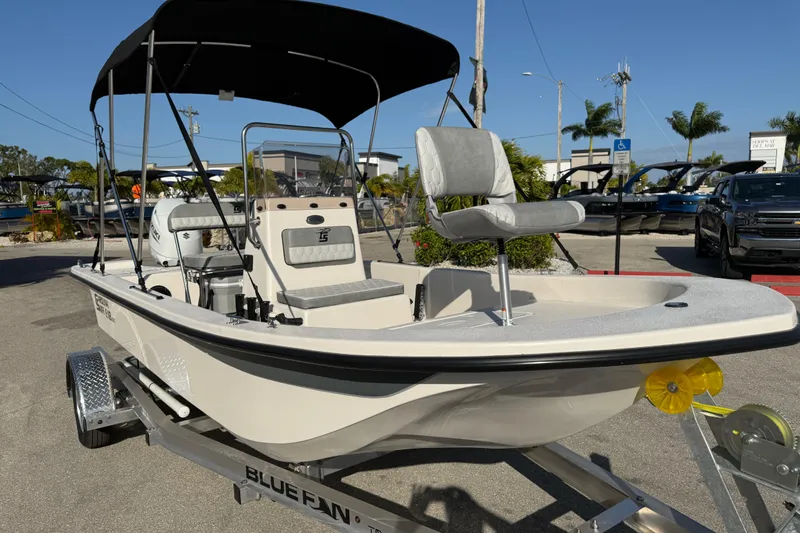 Slide: The Image of 2026 Carolina Skiff E18 JVX CC boat on trailer, outdoor dealership setting. - 4