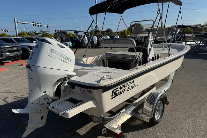 Slide: The Image of 2026 Carolina Skiff E18 JVX CC boat with Suzuki outboard motor on trailer. - 5