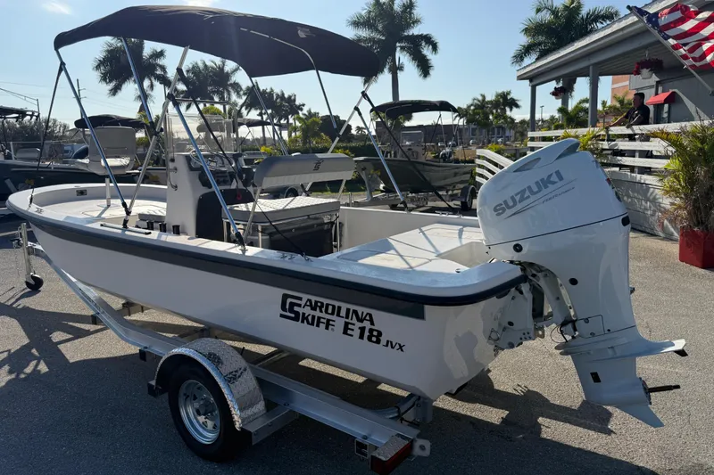 Slide: The Image of 2026 Carolina Skiff E18 JVX CC boat with Suzuki outboard motor on trailer. - 8