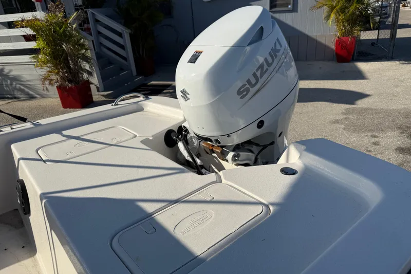 Slide: The Image of 2026 Carolina Skiff E18 JVX CC with Suzuki outboard motor, docked near plants. - 9
