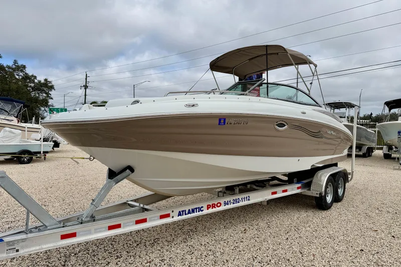Slide: The Image of 2012 SouthWind 2600 SD boat on trailer, parked outdoors under cloudy sky. - 2