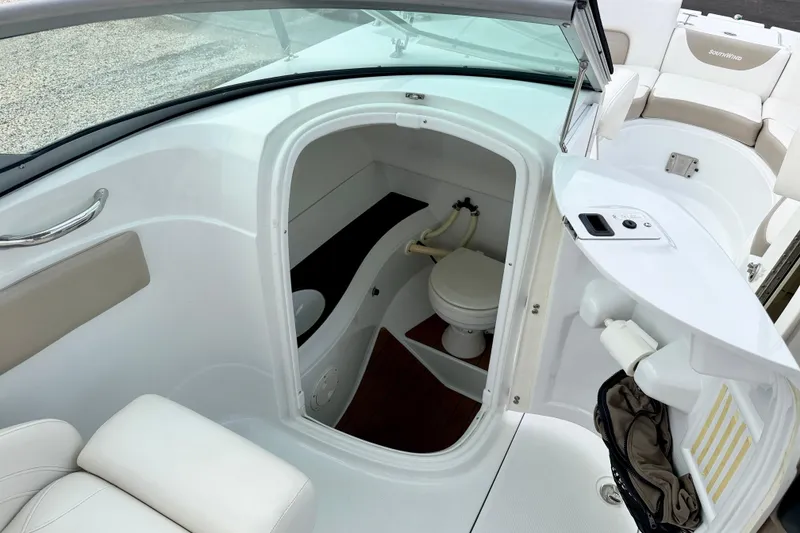 Slide: The Image of 2012 SouthWind 2600 SD boat interior with compact marine toilet and seating area. - 21