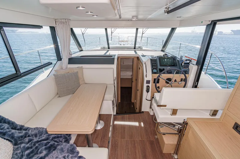Slide: The Image of Interior of 2025 Beneteau Swift Trawler 41, featuring helm and seating area with ocean view. - 18