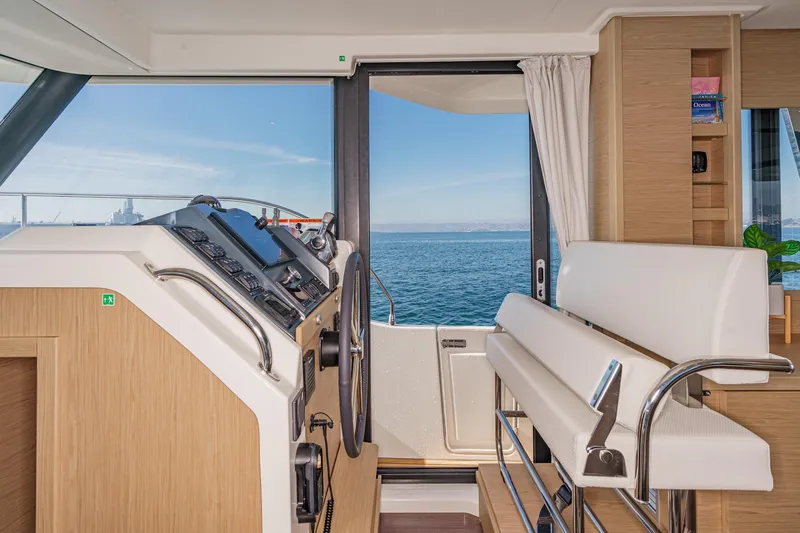Slide: The Image of Interior view of 2025 Beneteau Swift Trawler 41 helm, overlooking the ocean. - 22