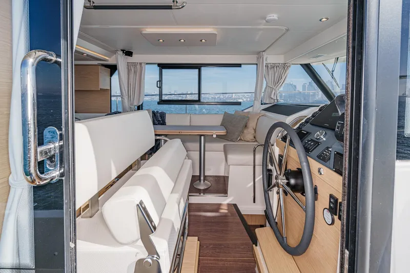 Slide: The Image of Interior of 2025 Beneteau Swift Trawler 41, featuring helm and seating area. - 24