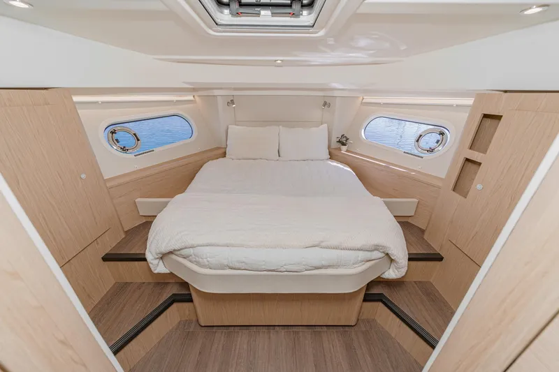 Slide: The Image of Luxurious cabin interior of 2025 Beneteau Swift Trawler 41 with cozy bed and porthole views. - 27