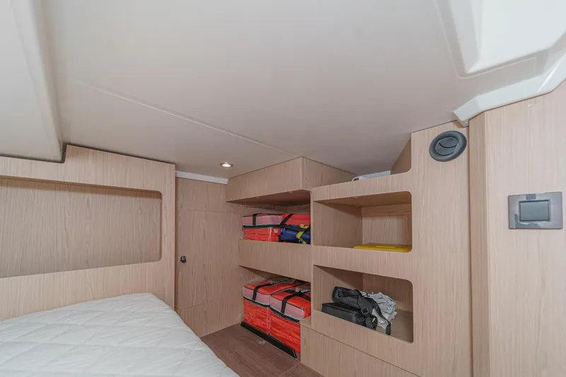 Slide: The Image of 2025 Beneteau Swift Trawler 41 cabin with wooden shelves and storage. - 35