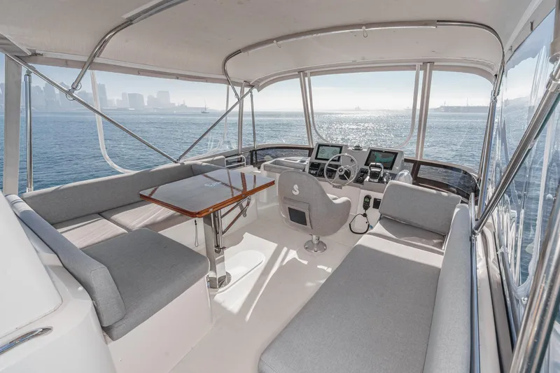 Slide: The Image of 2025 Beneteau Swift Trawler 41 interior with panoramic ocean view and modern helm. - 40
