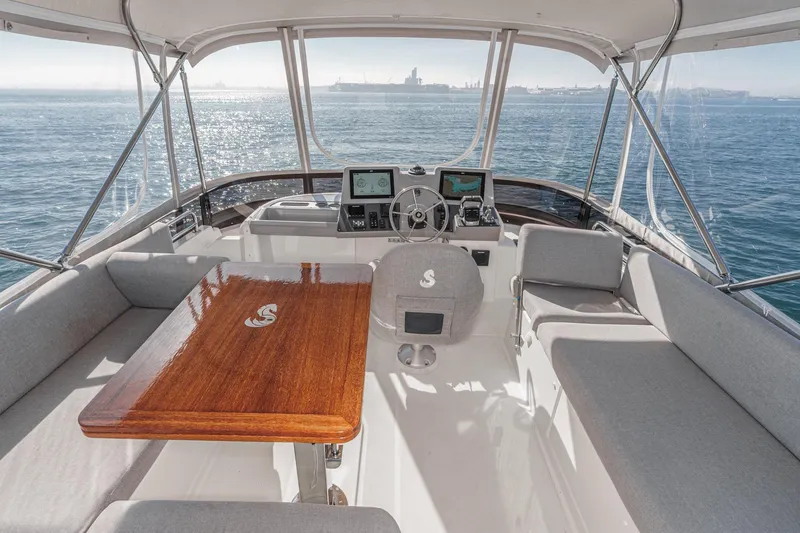 Slide: The Image of 2025 Beneteau Swift Trawler 41 cockpit with seating, table, and navigation equipment. - 41
