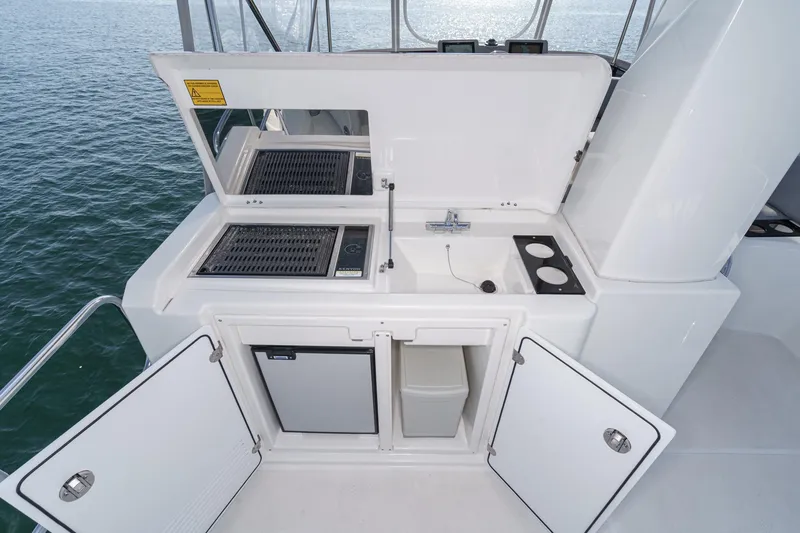 Slide: The Image of Outdoor kitchen on 2025 Beneteau Swift Trawler 41, featuring grill, sink, and storage. - 46