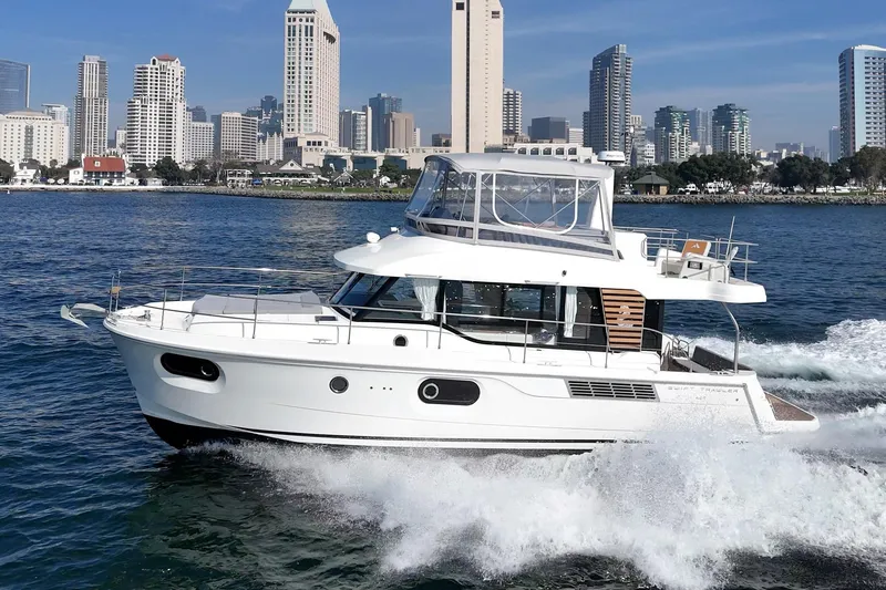 Slide: The Image of 2025 Beneteau Swift Trawler 41 cruising near city skyline on a sunny day. - 62