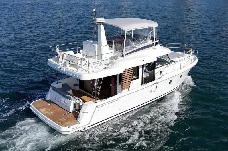 Slide: The Image of 2025 Beneteau Swift Trawler 41 cruising on open water, rear view. - 66
