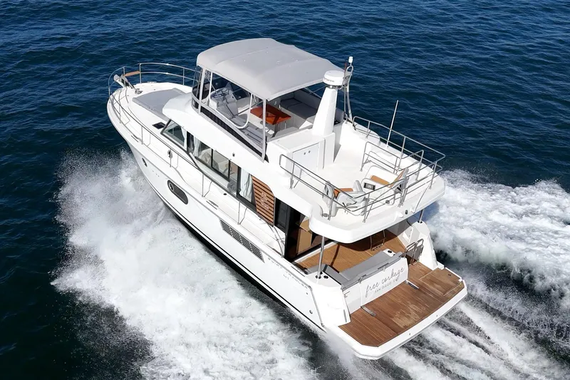 Slide: The Image of 2025 Beneteau Swift Trawler 41 cruising on open water, showcasing sleek design and spacious deck. - 70