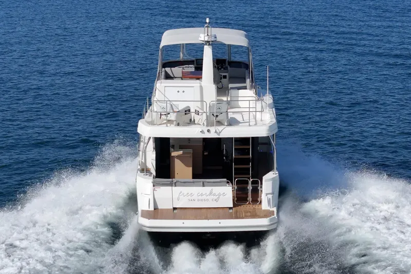 Slide: The Image of 2025 Beneteau Swift Trawler 41 cruising on open water, rear view. - 71