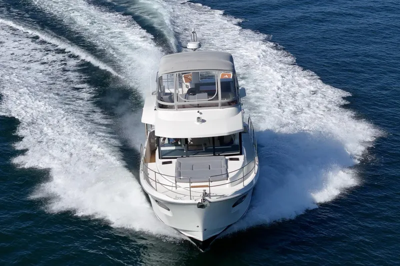 Slide: The Image of 2025 Beneteau Swift Trawler 41 cruising on open water, creating a dynamic wake. - 77
