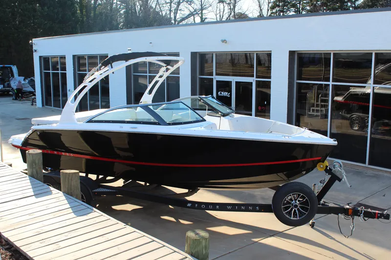 The Image of 2026 Four Winns H2 Freedom boat on trailer outside showroom. - 1