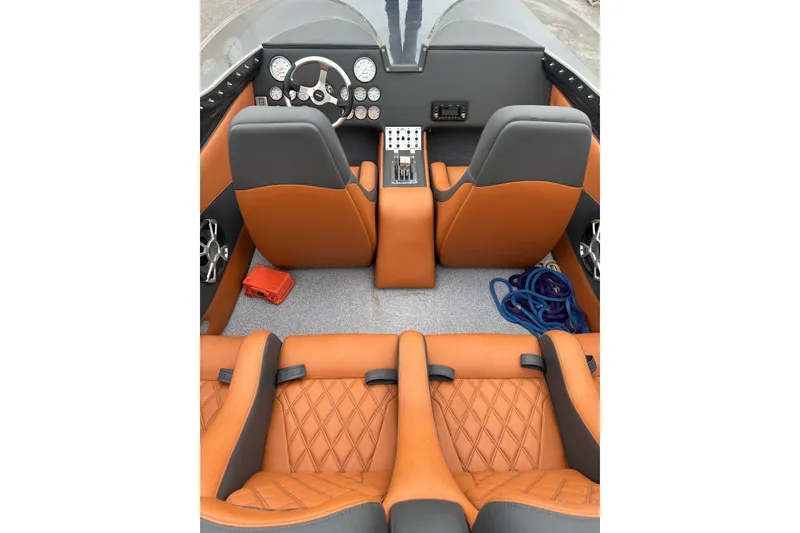 Slide: The Image of 2008 Motion Marine 35 XP boat interior with orange and gray seating, dashboard, and controls. - 8